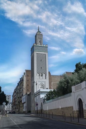 A clear day view of the Grand Mosque of Paris with its intricate architecture and a blue sky background.