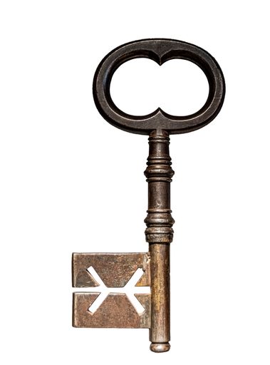 A vertical shot of an old key on a white background in Paris, France