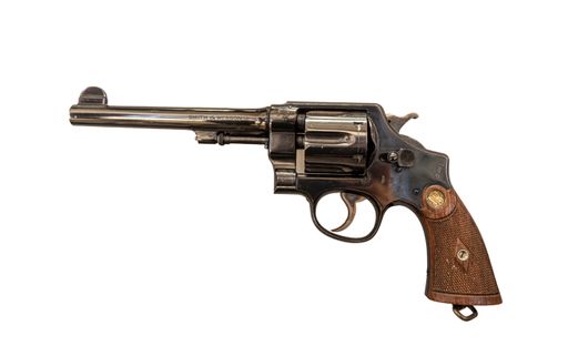A closeup shot of a revolver used during a war on a white background in Paris, France