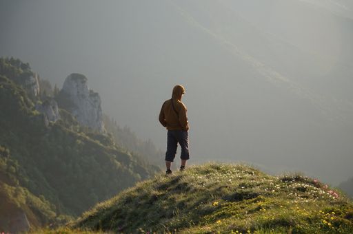 A male hiker on top of a mountain enjoying the view
