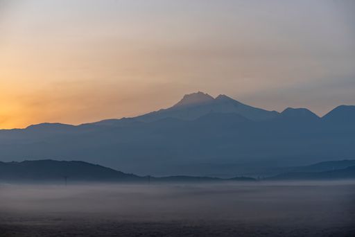 The beautiful sunrise over the Erciyes mountain and calm river on a misty morning in Kayseri, Turkey