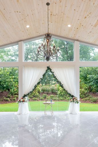 A vertical shot of the beautiful altar decorated with white curtains in a wedding hall