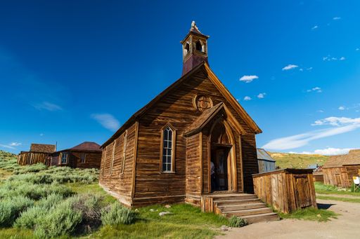 A well-preserved wooden church in the ghost town of Bodie, California, under a clear blue sky