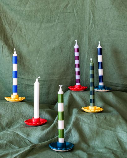 Artistic arrangement of ceramic candlesticks on a green fabric background