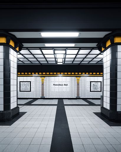 An Empty Paracelsus-Bad subway station in Berlin with modern architectural design and tiled walls.