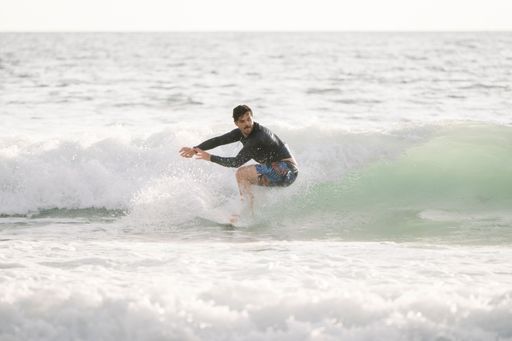 A man surfing on a wave in the ocean on a sunny day