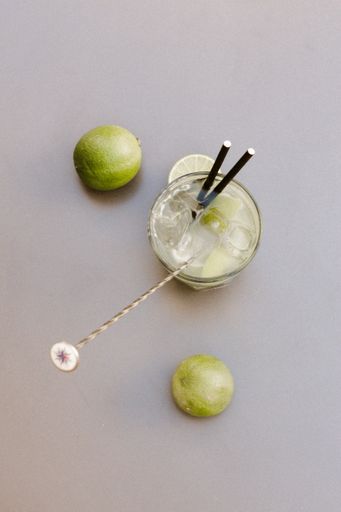 Preparation Cocktail with lemon with a woman's hand on a light table.
