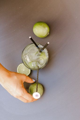 Preparation Cocktail with lemon with a woman's hand on a light table.