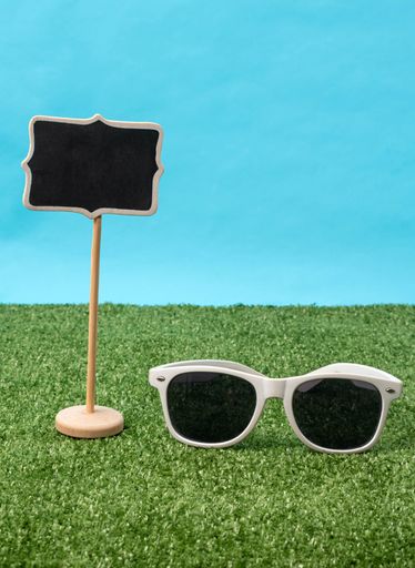 A vertical shot a sunglass and a wooden sign - Tokyo Olympic Games 2021