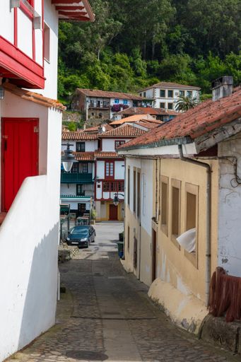 A street with traditional beautiful houses of the village of Tazones in Spain, vertical shot
