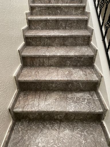 A closeup of granite steps and cast iron handrail
