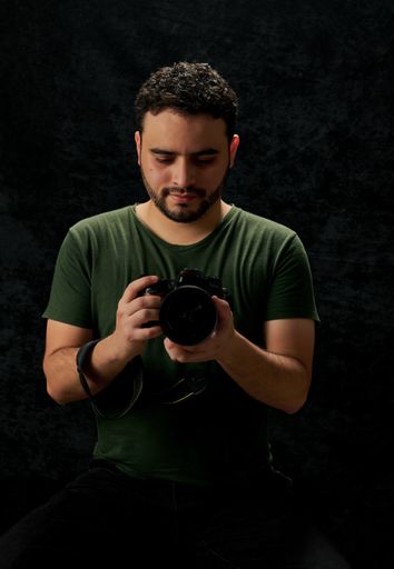A handsome young man from Columbia fixing the lens of a professional camera