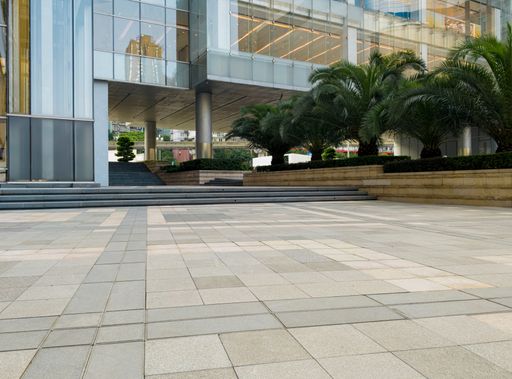 A close-up of modern urban architecture with glass facade and stone pavement in a city environment