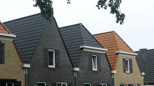 A row of modern houses with distinct colored roofs in a residential area