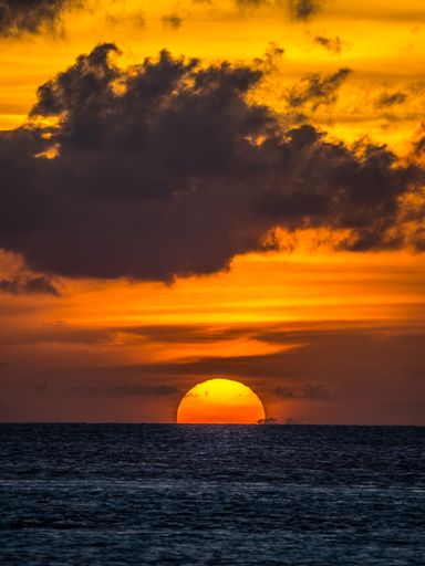 A vertical shot of an ocean during a beautiful sunset