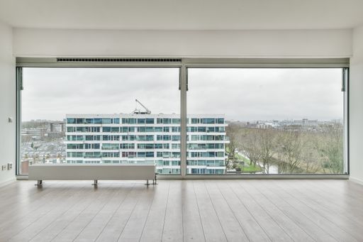 an empty room with laminate flooring and french windows