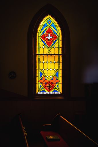 A vertical shot of a stained glass window in the church