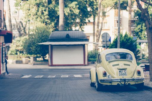 A vintage yellow beetle parked along the street in Cartagena, Spain