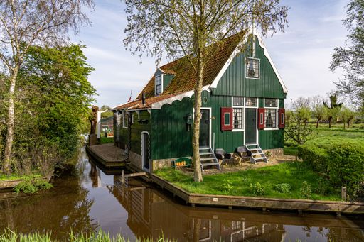 A scenic view of Zaanse Schans, village with centuries-old windmills and timber houses by a river
