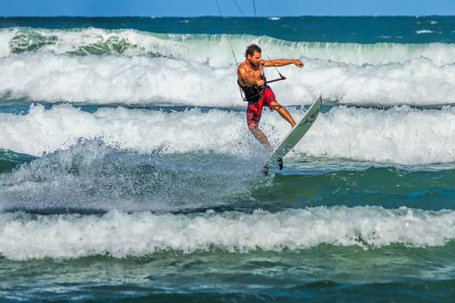 A kite surfer skillfully riding waves along the Australian coast under a clear sky