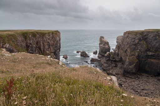 The view of rugged cliffs and sea on a cloudy day. Pembrokeshire Coast National Park, Wales