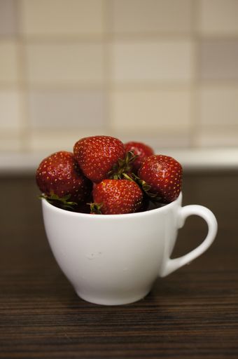 A closeup shot of sweet, fresh strawberries in a white  mug