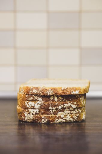 A soft focus of slices of bread with grains on a wooden table