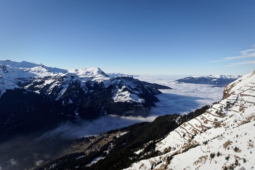 High mountain landscape with a sea of clouds covering the valley between the snowy landscape
