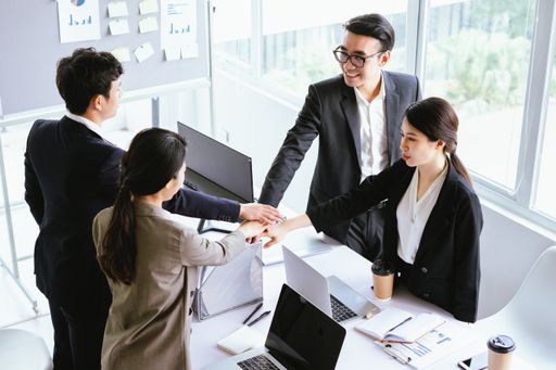 A young Vietnamese business team in suits unitedly working on the project in the office