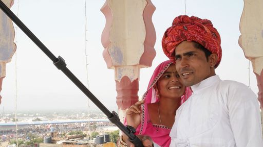 Cute young newlyweds in traditional Indian clothes taking selfies