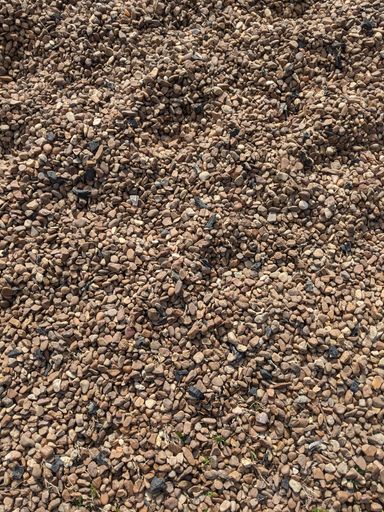 A vertical shot of gravel on the ground on a sunny day - perfect for wallpapers and textur