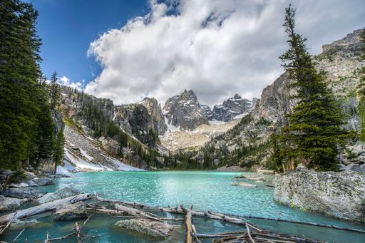 A stunning mountain landscape with turquoise Lake Delta and a cloudy sky in Grand Teton Wyoming
