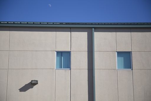 A building with two windows under a blue sky