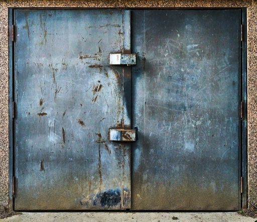 A closeup of a closed metal garage doors with scratches and rust