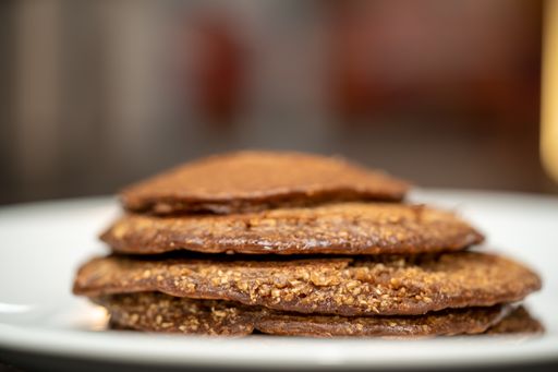 A closeup shot of tasty brown round cookies on a white plate