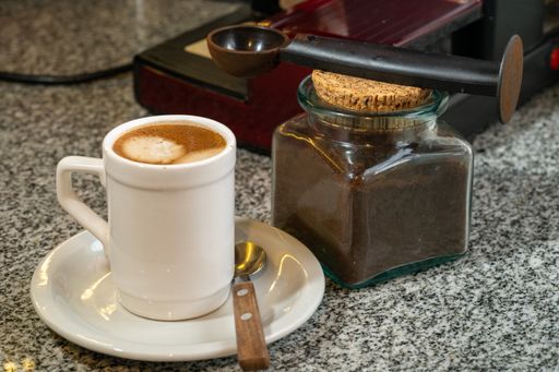 a beautiful shot of coffeecup next to the jar with coffee