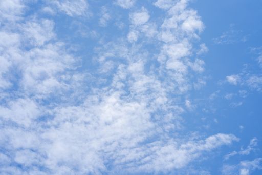 A low angle shot of white fluffy clouds on a blue sky - perfect for wallpaper