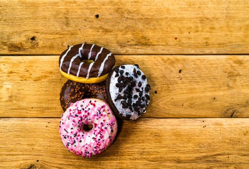 An overhead shot of colorful donuts with glazed sprinkles and chocolate frosting