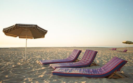 An umbrella and folding chairs on the beach under the sunlight - perfect for wallpapers