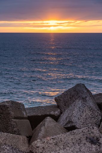A vertical shot of the sunset sky over the sea in summer
