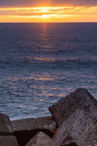 A vertical shot of the sunset sky over the sea in summer