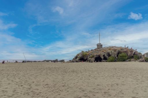A shot of the Sumner Beach in Christchurch with an old lava flow remnant known as Cave Rock in New Zealand.