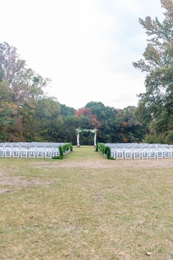 An empty outdoor wedding venue with a forest in the background
