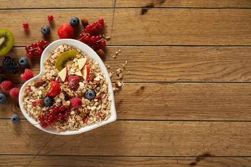 A top view of healthy breakfast bowl with oat and various fresh fruits and berries