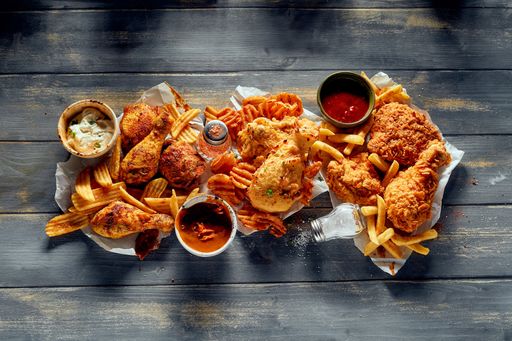 A top view shot of tasty various French fries and crispy potato chips in baskets on white background