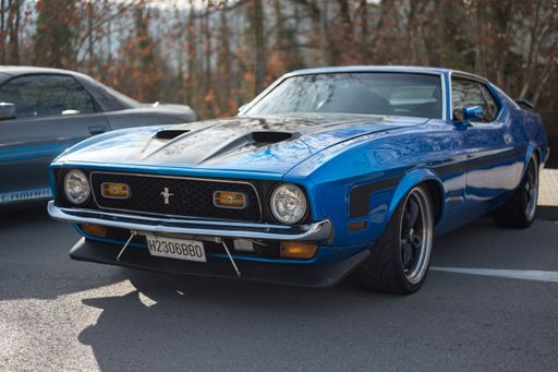 Front view of a classic American sports car Ford Mustang Mach 1 1971 first generation faclift, it is blue with black stripes