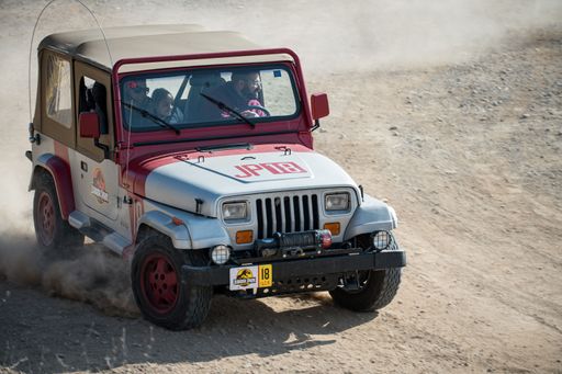 American Jeep Wrangler YJ SUV from 1987 - 1996 from the movie Jurassic Park running, skidding and kicking up dirt on the track
