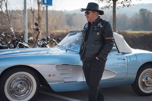 Detail of a typical American character dressed in a black leather jacket, hat and sunglasses standing