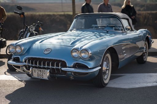Front view of a classic American sports car, the first generation Chevrolet Corvette C1 in light blue color, is parked on the street