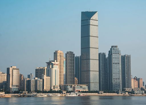 The tall buildings along the Yangtze River with ships docked under a clear sky in Wuhan, China